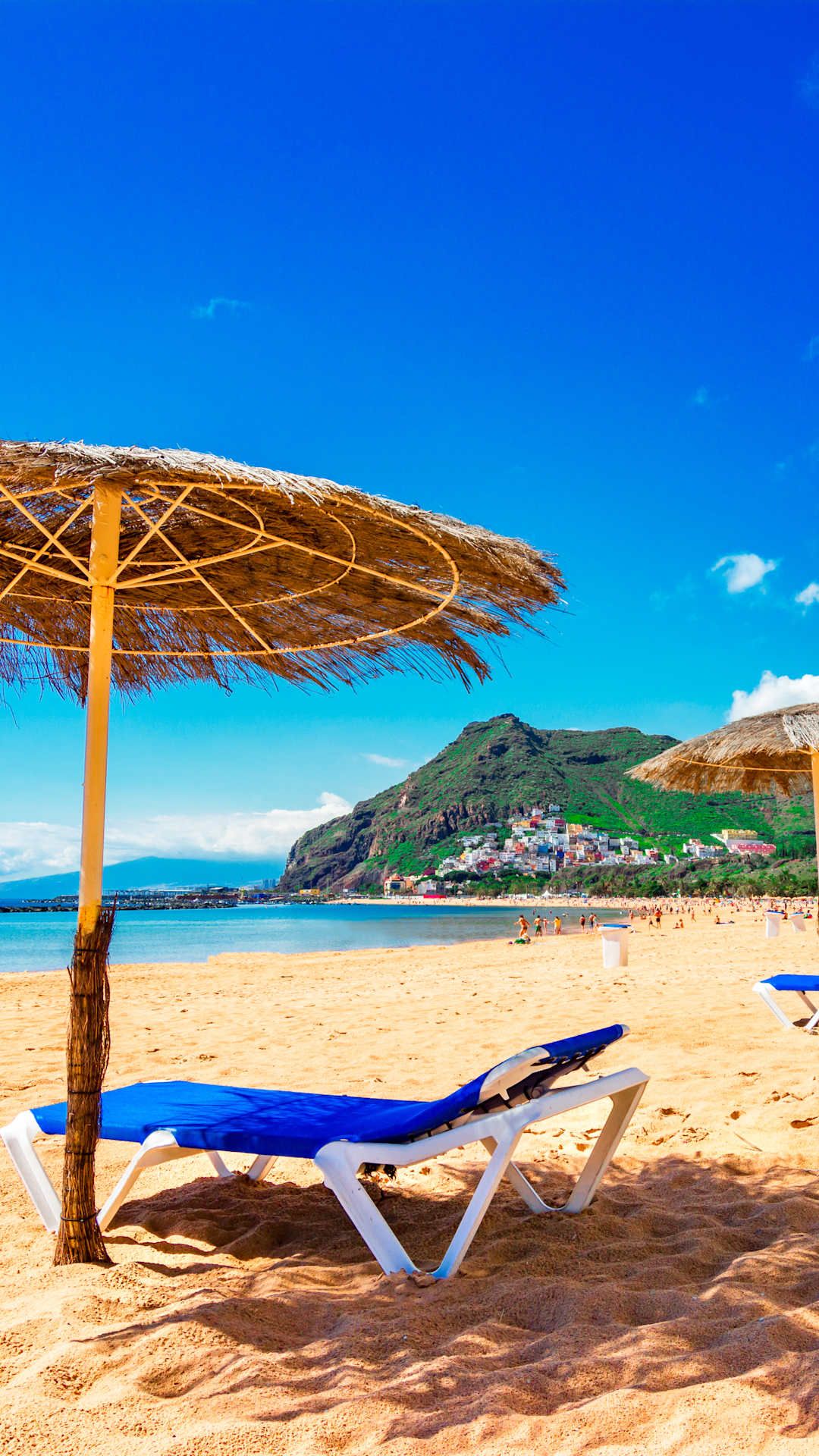 Beach view in the canary islands from chair with straw umbrella